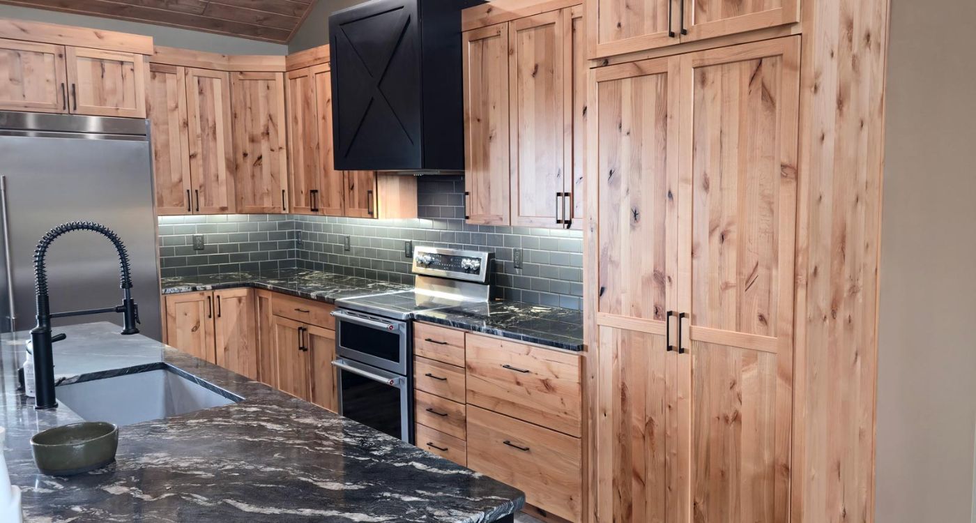Custom kitchen with dark stained cabinets, patterned tile backsplash and large island, Sioux Falls area