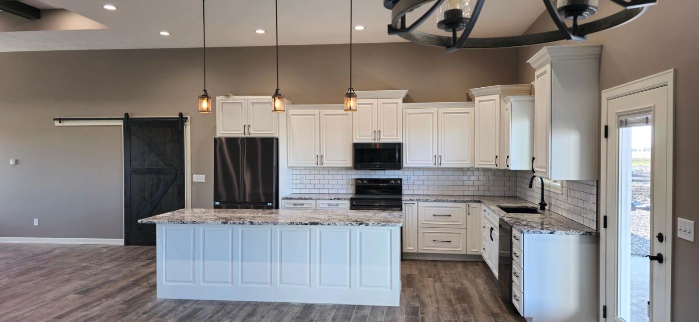 Custom kitchen with panelled cabinetry, pendant lighting and barn door, custom home in South Dakota